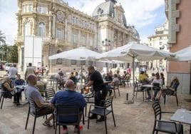 Clientes en una terraza frente al Ayuntamiento.