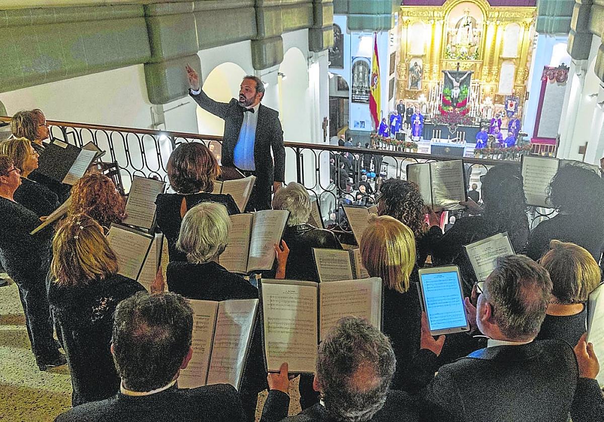 La coral Tomás Luis de Victoria canta durante la solemne eucaristía del Cristo del Socorro.