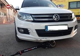 El patinete del joven herido, bajo el coche contra el que chocó.