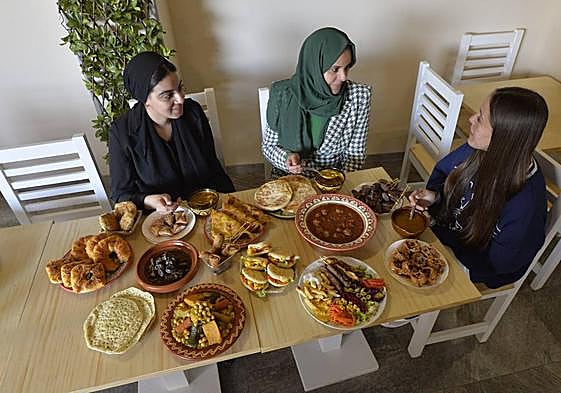 La chef de Al Baraka, Karima Belamrissi (c), disfruta de varios platos elaborados por ella misma en su restaurante junto a dos comensales más.