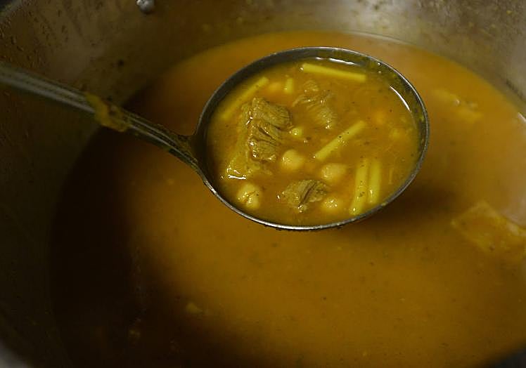 Imagen principal - Una cucharada de la sopa harira recién elaborada. Cuscús con carne de ternera, garbanzos y verduras. Batbout o pan bao con pollo al curry, lechuga y tomate fresco.