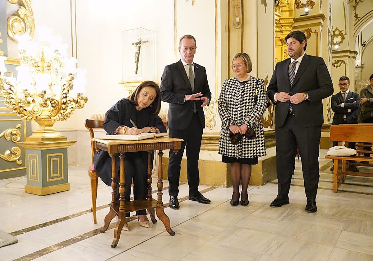 La pregonera de la Semana Santa Catalina Miñarro firma en el libro de honor del Paso Blanco ante el presidente de la Región, el presidente de la cofradía y la presidenta del Coro de Damas. ANDRÉS RIBÓN / AGM