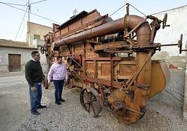 Joaquín Belmonte y Raúl Jiménez con la centenaria trilladora-aventadora, en Los Dolores.