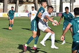 Piqueras controla el balón con el pecho presionado por un defensa.