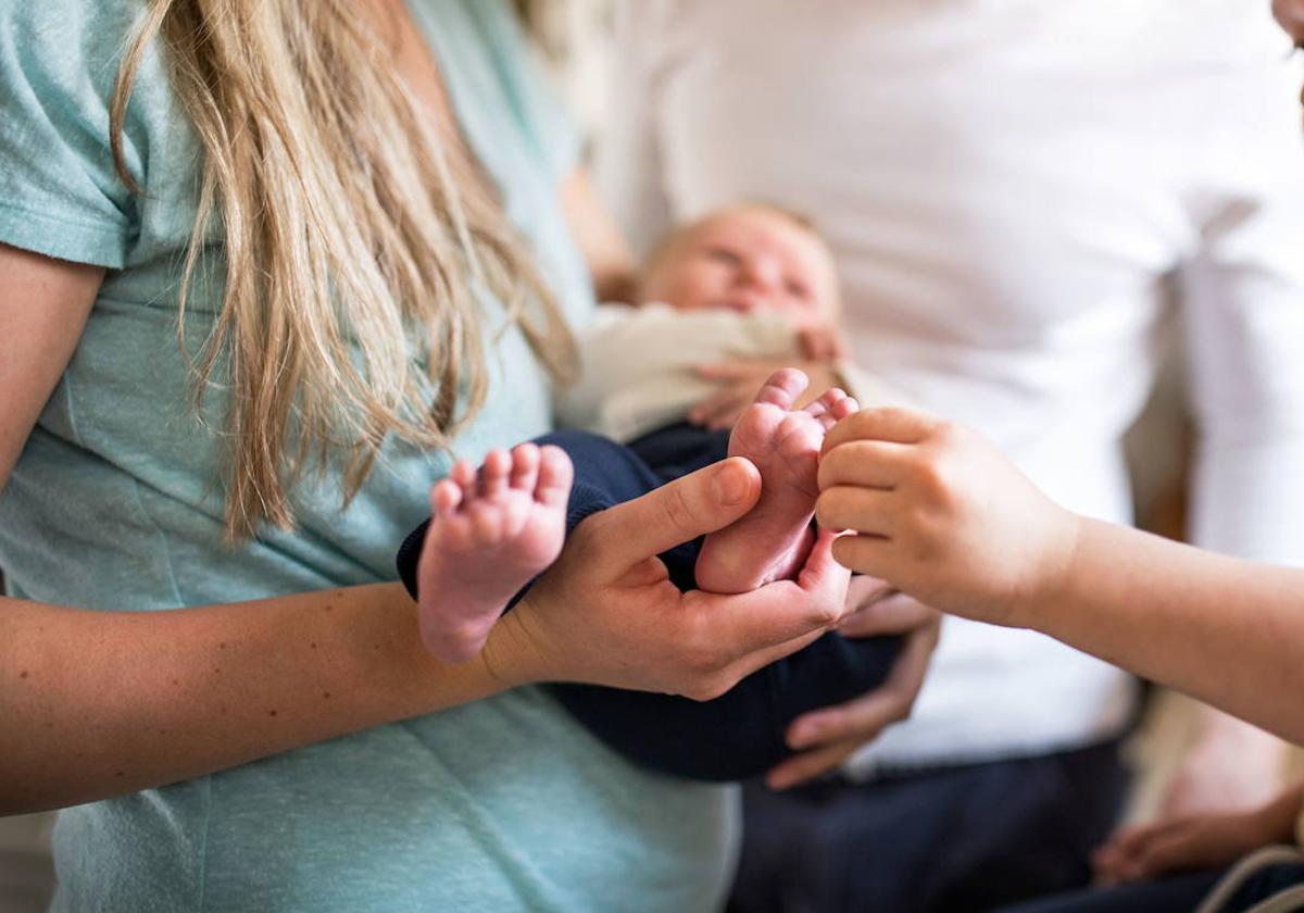 Una madre sostiene en brazos a su bebé.