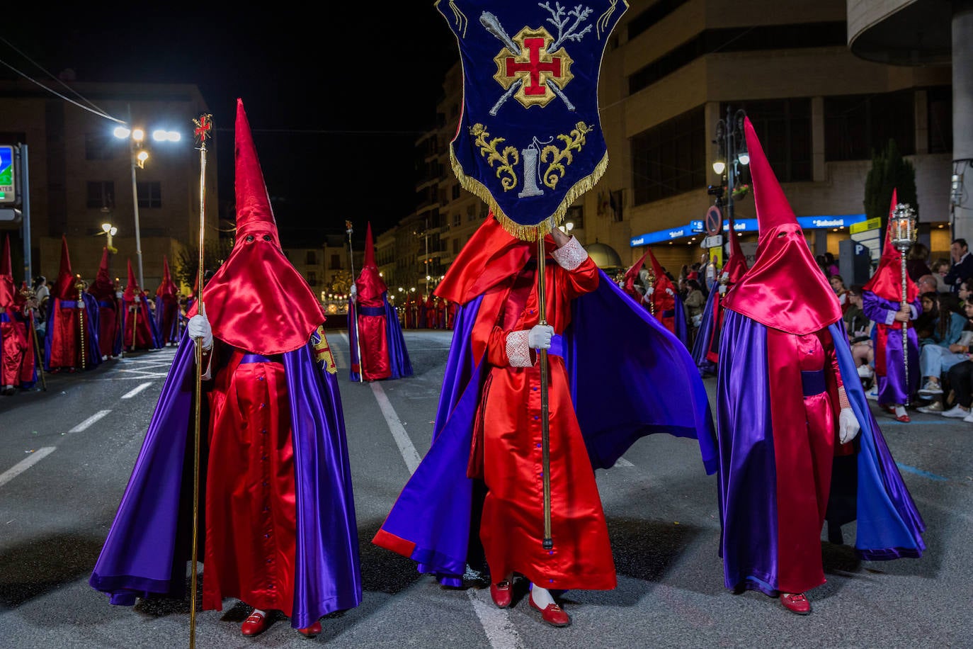 Grupo de niños nazarenos reparte caramelos entre los asistentes