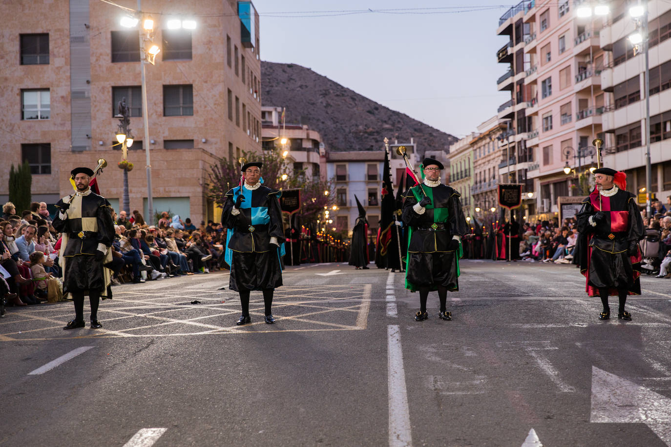 Los cuatro heraldos con los colores distintivos de las cuatro hermandades que componen la Cofradía del Perdón