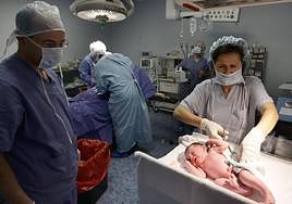 Una matrona atiende a un recién nacido en la maternidad de un hospital.