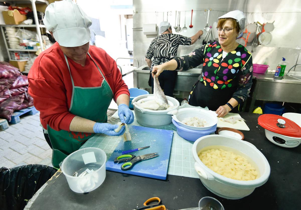 Cocineras de la peña El Pimiento preparan bacalao para los platos que empezarán a servir este domingo.