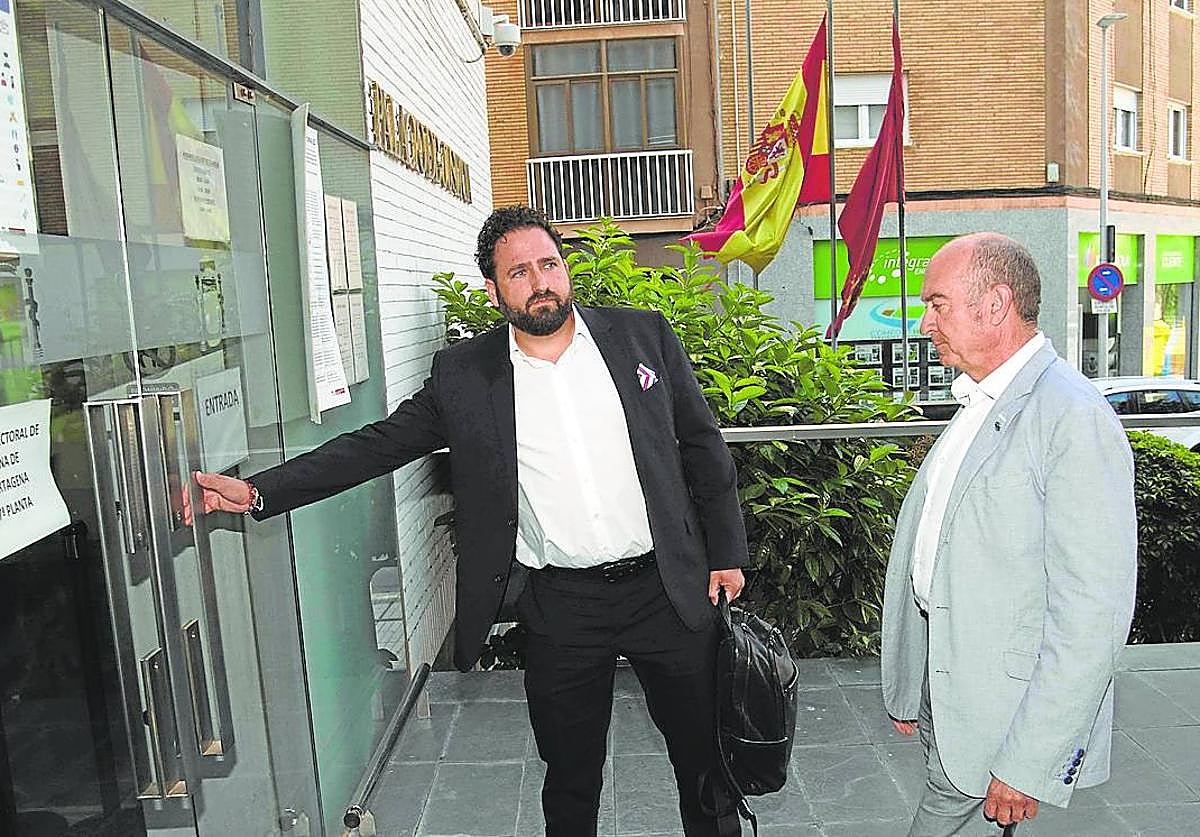 El abogado de Fermín Rol, Pablo Martínez, le abre la puerta de los juzgados, este lunes en Cartagena.
