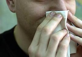 Un joven con molestias en la nariz en imagen de archivo.