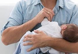 Un padre con su bebé en brazos.