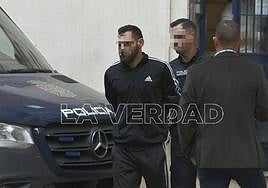 Uno de los tres detenidos, este sábado, al ser trasladado a los juzgados.