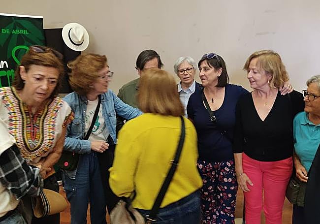 El instante en el que la concejala, de amarillo, trata de quitar la bandera de la foto.