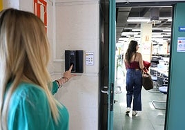 Una trabajadora introduce el dedo índice en el lector de huella digital antes de iniciar su jornada laboral.