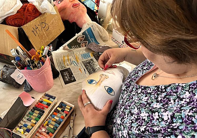 Una vez relleno el molde de la cabeza con fibra, se procede a pintar los rasgos de la cara con ceras de colores.