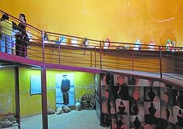 Varias personas visitando la exposición en el Aljibón de Corverica en Fuente Álamo.