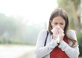 Una chica estornudando por la alergia.