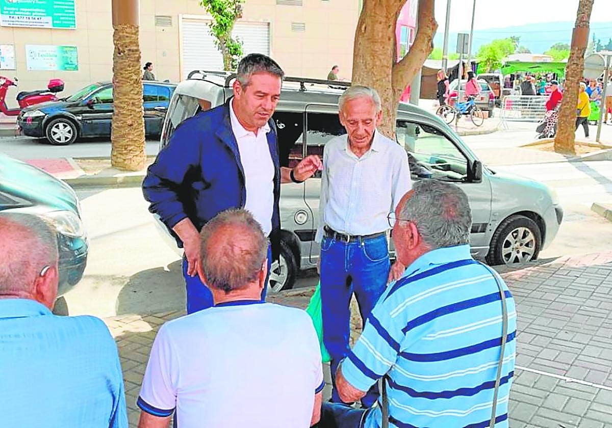 El alcalde de Alcantarilla, Joaquín Buendía, charla con cuatro vecinos, ayer por la mañana, en una calle del municipio.