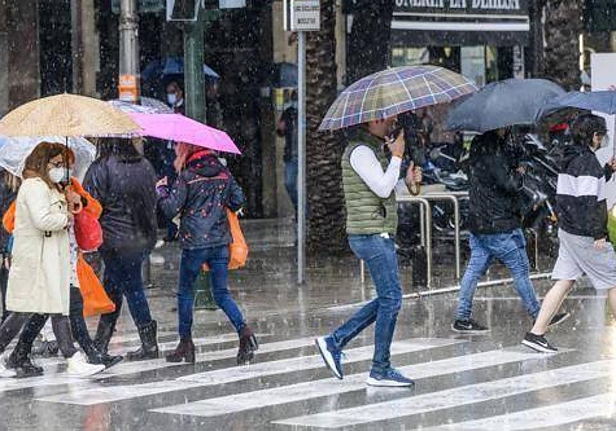 Varias personas caminan por la calle en un día lluvioso, en una imagen de archivo.