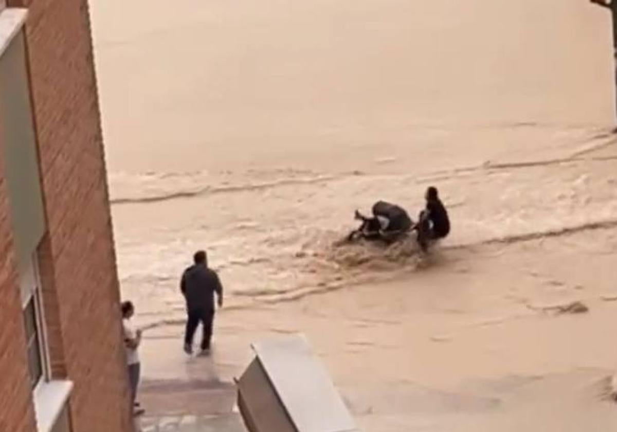 Una mujer trata de cruzar la calle con un carrito de bebé.