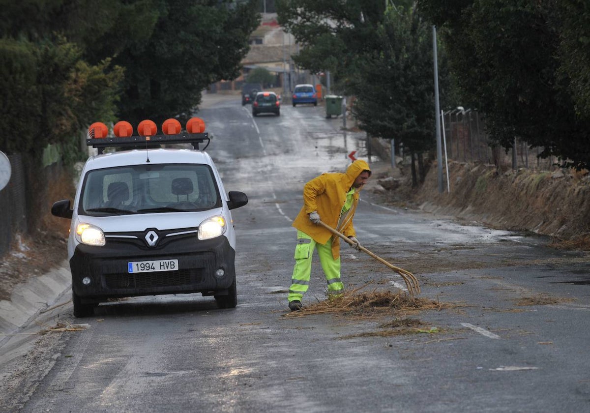 Un trabajador retira material arrastrado por la lluvia en Cieza.