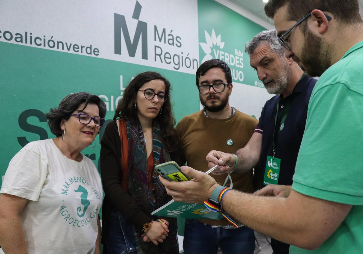 Helena Vidal y Óscar Urralburu siguen los resultados de las elecciones con rostros serios en la sede del partido en Murcia, este domingo.