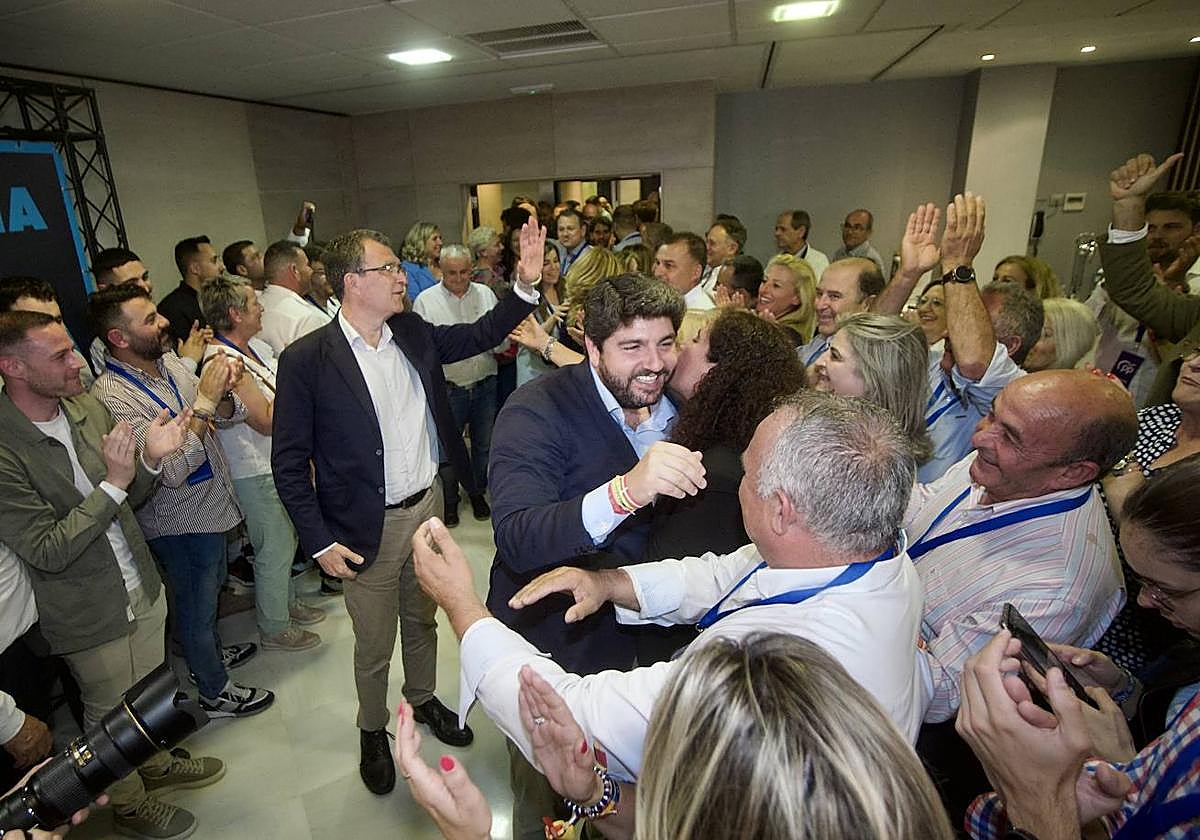 López Miras se abraza con simpatizantes y colaboradores del PP, con Ballesta a su espalda, tras confirmarse su victoria electoral.
