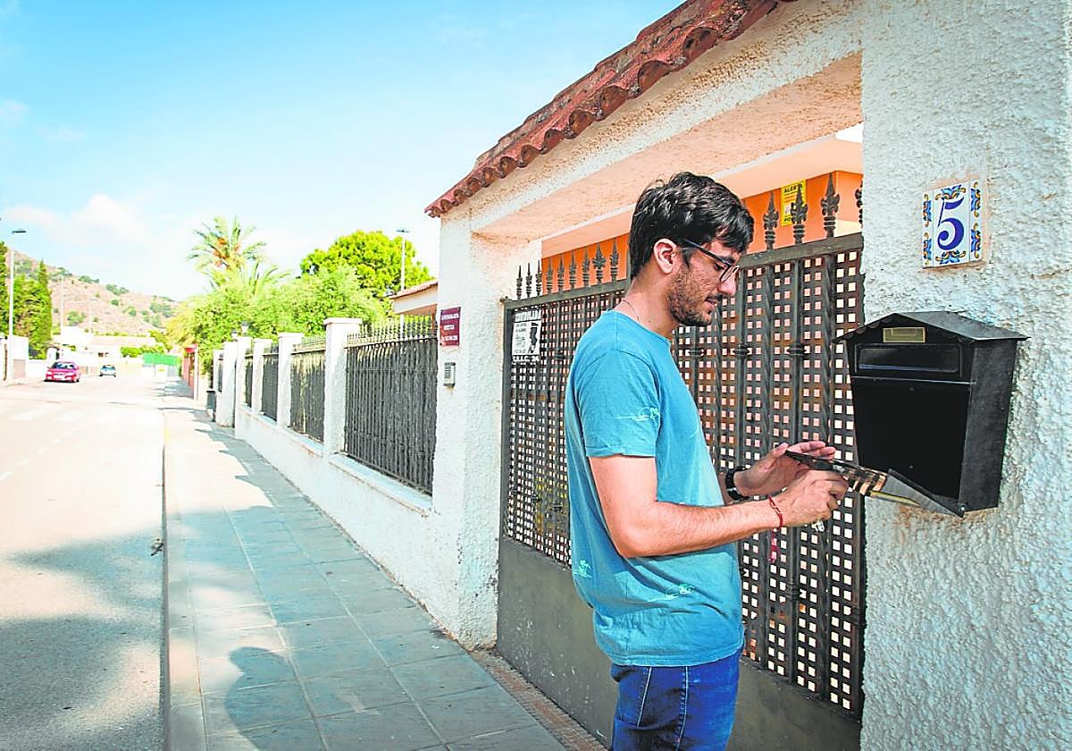Un vecino de Montepinar abre el buzón en busca de cartas.