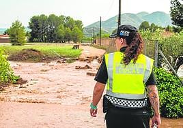 Una agente de la Policía Local de Yecla observa un camino anegado, ayer por la mañana.