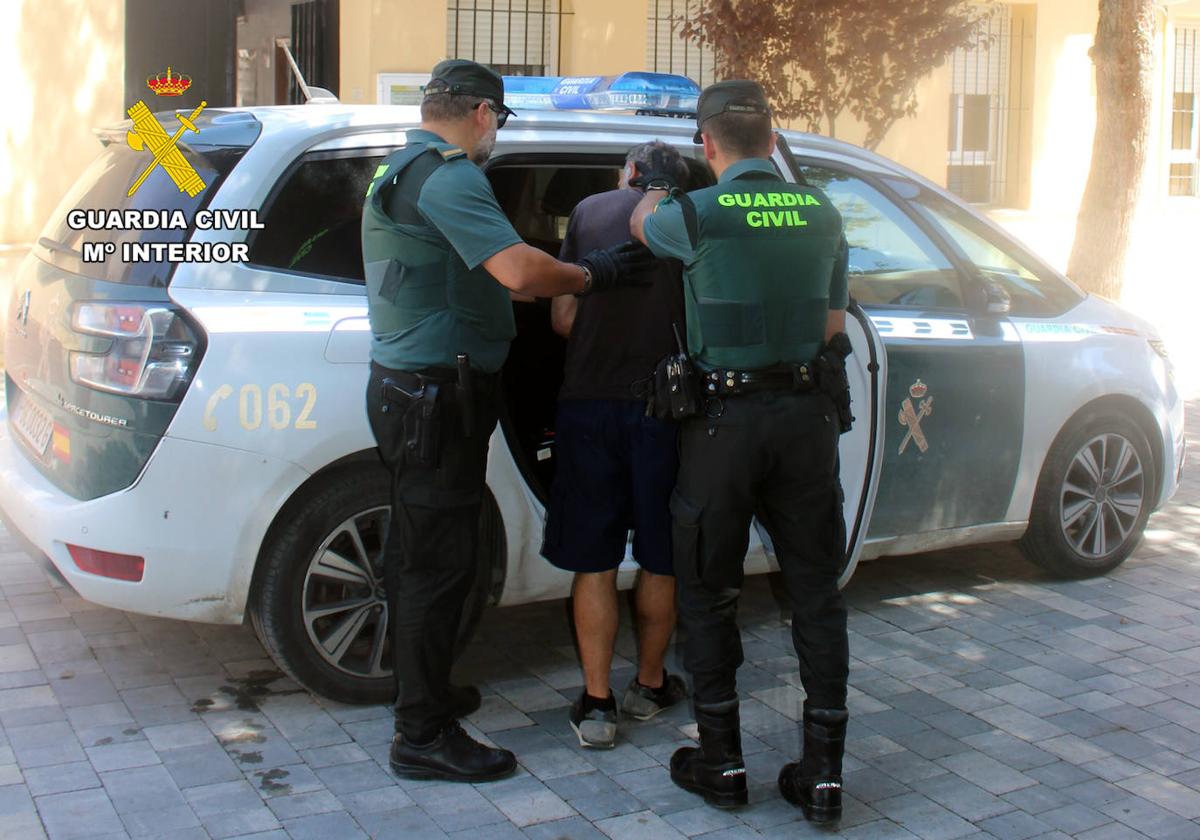 Dos agentes de la Guardia Civil junto al detenido.