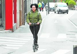 Una mujer circula en un patinete eléctrico por una calle de Lorca.