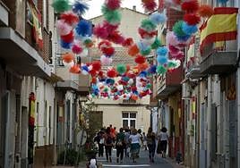 Calles engalanadas con guirnaldas de colores y banderines, en la pedanía de Alquerías, con motivo de sus fiestas patronales.