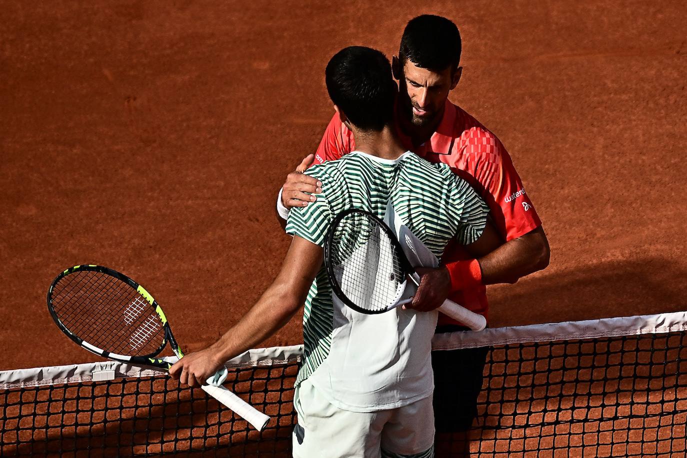 Djokovic y Alcaraz se abrazan al terminar el partido del viernes.