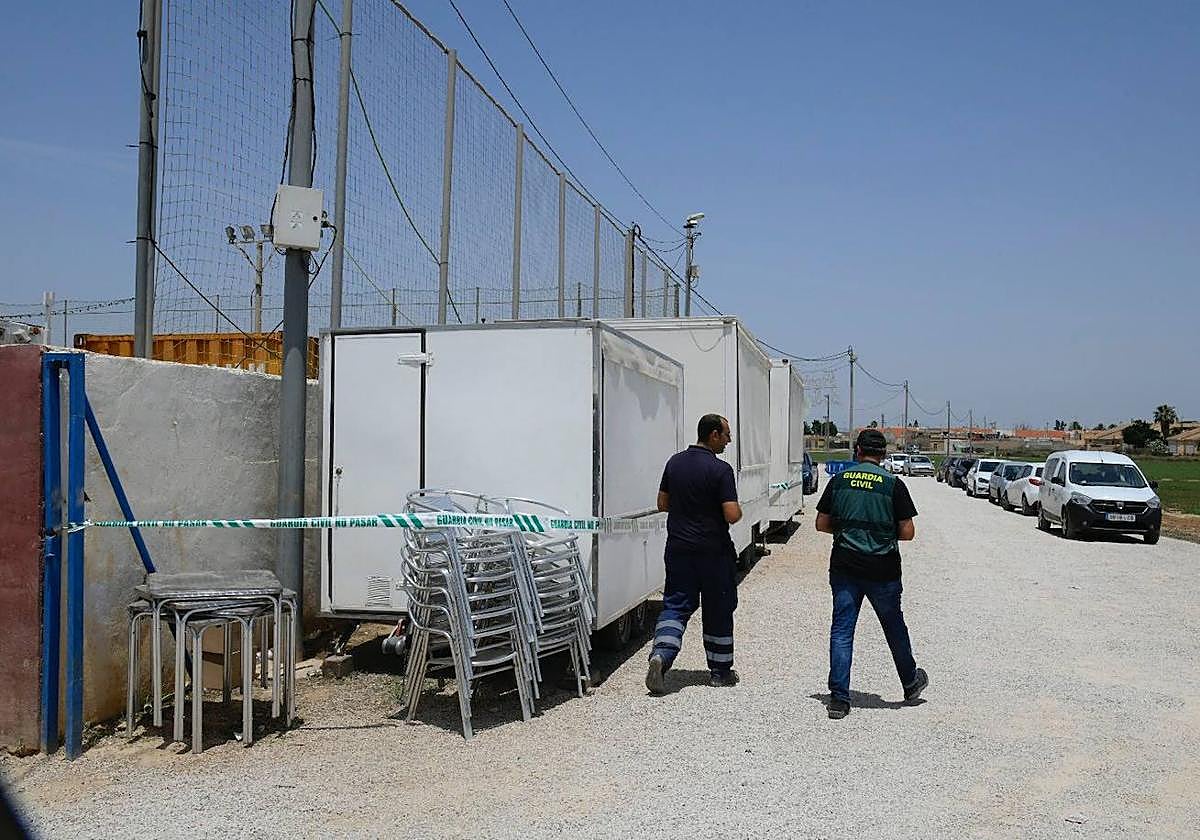 Un técnico municipal y un guardia civil, junto a la caseta precintada, fuera del recinto festero de El Albujón.