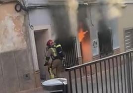 Un bombero se dispone a entrar en la vivienda incendiada.