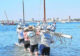 Regatistas se dirigen asu embarcacióncargando la botabara.