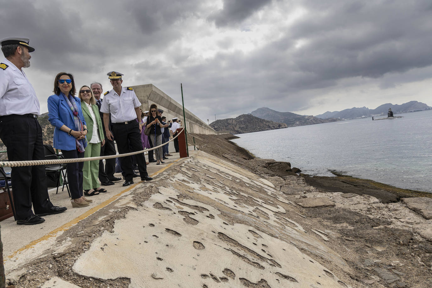 El S-81 'Isaac Peral' navega frente al dique donde se encuentra la ministra Robles acompañada de altos cargos militares y de Navantia.