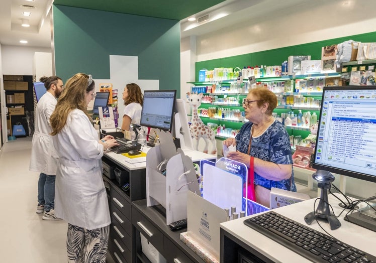 Farmacéuticos y clientes, este miércoles en una oficina de farmacia de Murcia.