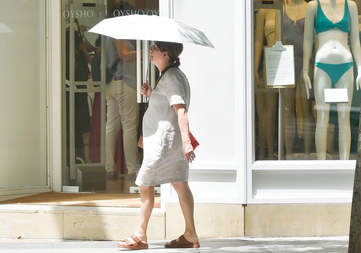 Una mujer se protege del sol con un paraguas, este lunes en el centro de Murcia.