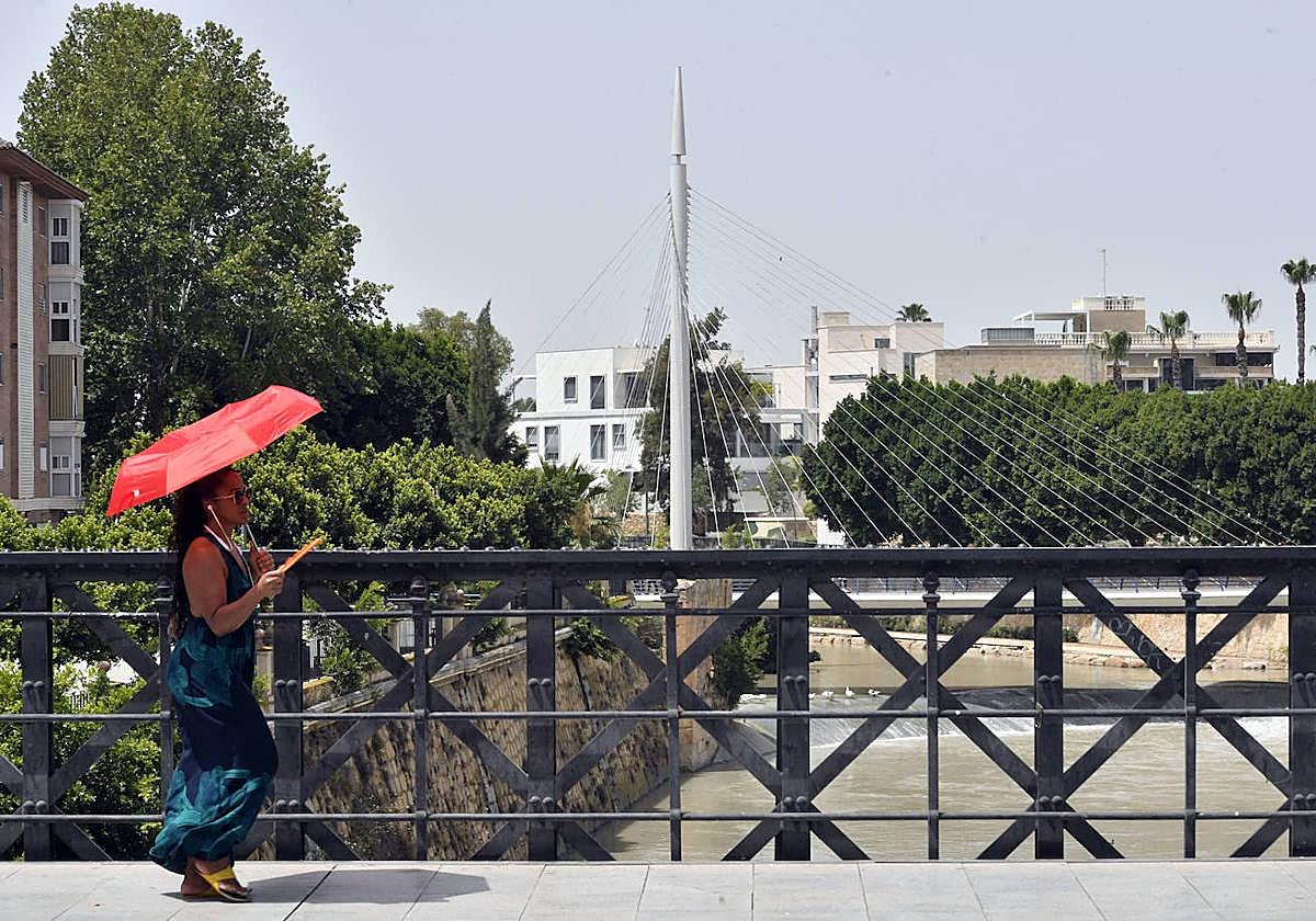 Una viandante en el Puente Viejo de Murcia, esta semana, en plena ola de calor.