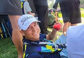 Un voluntario murciano con una gorra y un corazón firmado por el el jugador norteamericano Mickelson