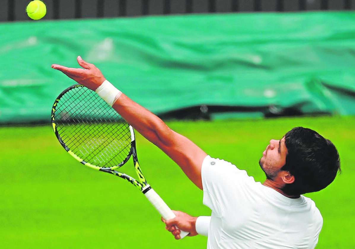 Alcaraz lanza la bola al aire para sacar en un juego de la final de Wimbledon contra Djokovic, el domingo.