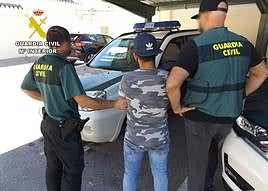 Dos agentes arrestan a uno de los responsables del robo.