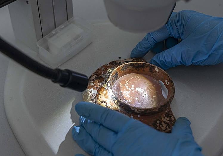 Imagen principal - Grafito de un falo en la base de un cuenco cerámico; sello con la marca 'Pella Trebel' en la boca de un ánfora y fragmentos de discos de lucernas romanas con escenas eróticas. 