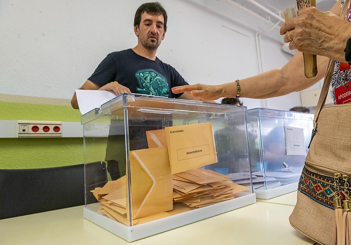 Una votante introduce su voto en la urna.