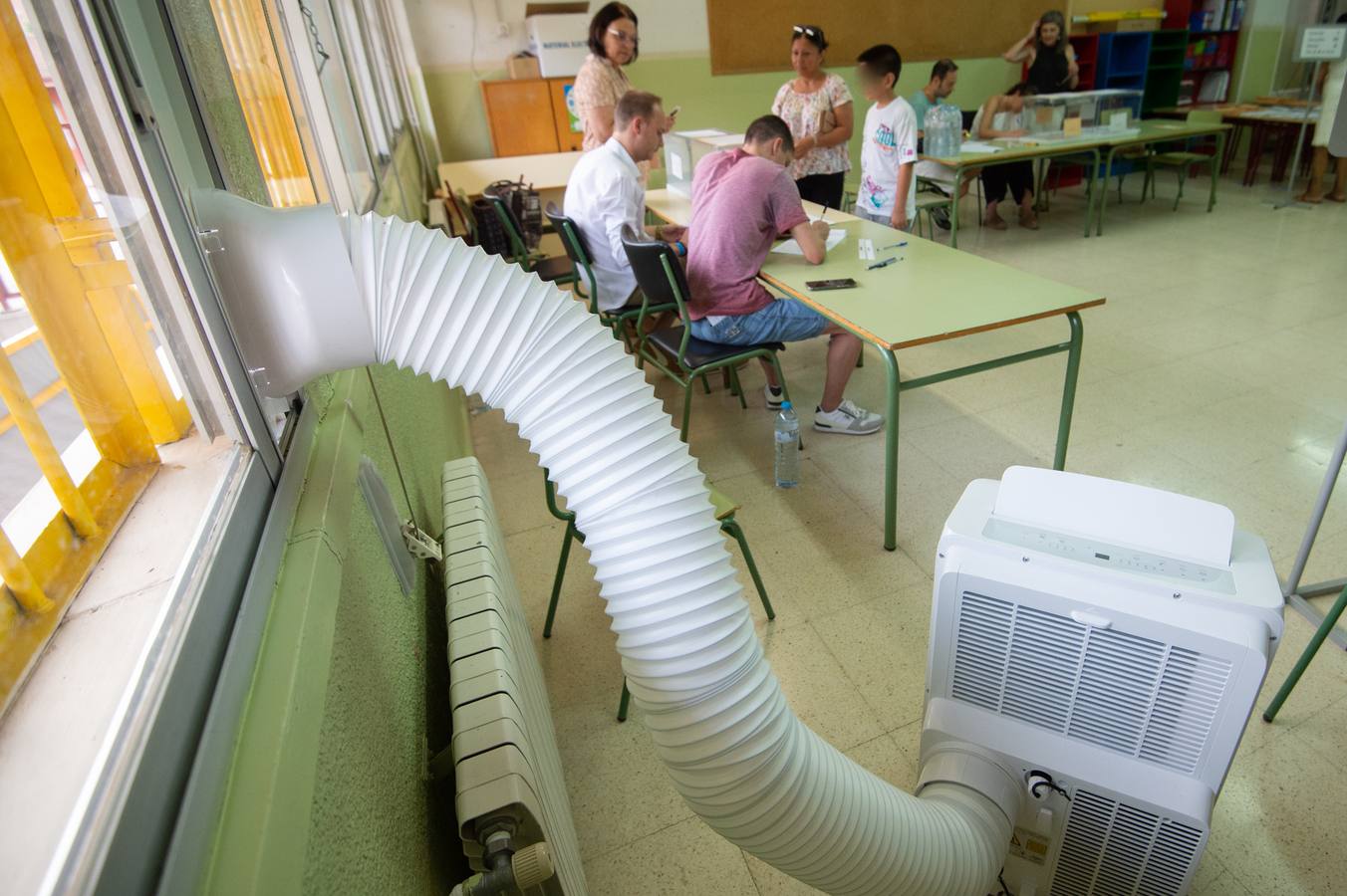 Un aparato de aire acondicionado alivia el calor en un colegio electoral de Murcia.