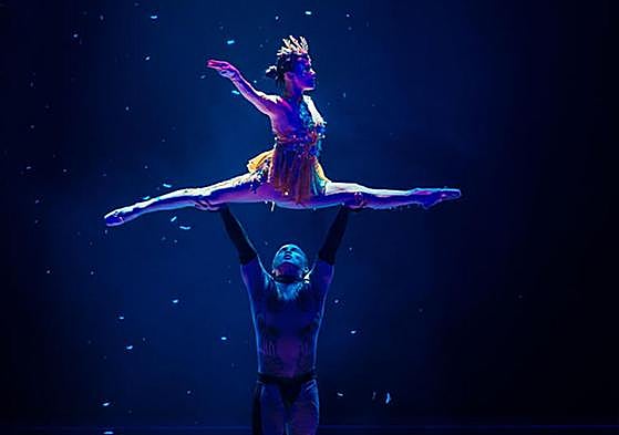 Dos artistas del espectáculo realizan un número acrobático.