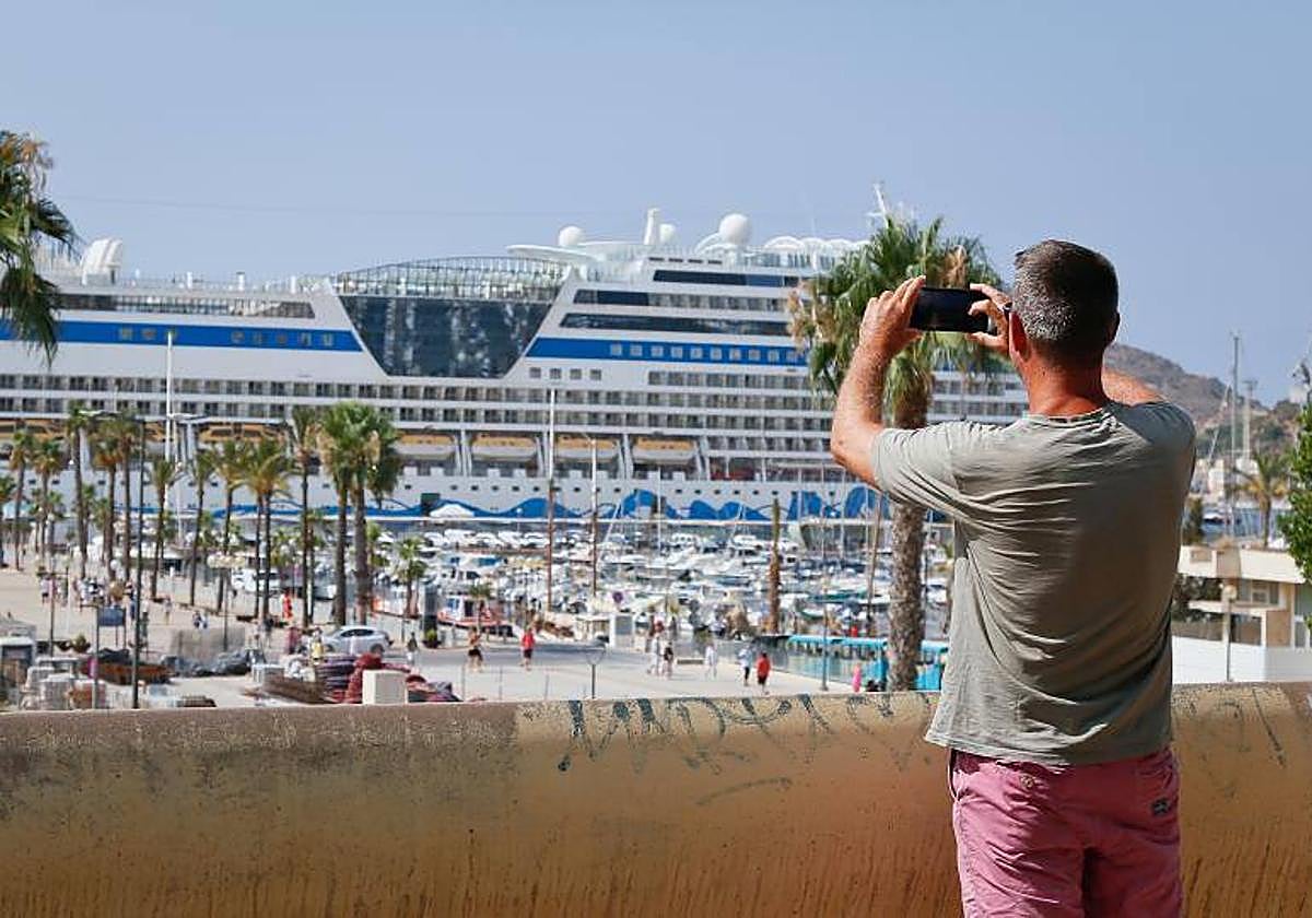 Un hombre toma una foto de un crucero en el puerto de Cartagena en una imagen de archivo.