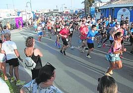 Los corredores pasan junto al puesto de la Policía Local, ayer, en el cross de Cabo de Palos, arropados por familiares y amigos.